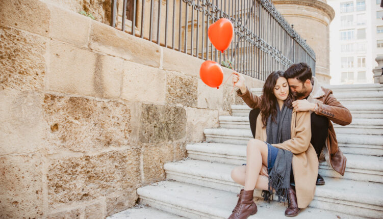 Couple mignon avec des ballons dans les escaliers